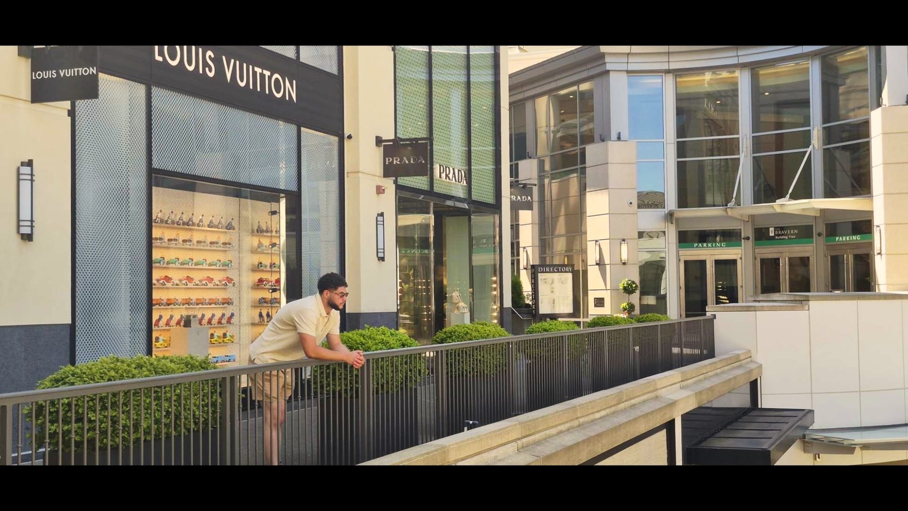 Joshua Daniels on a balcony outside Louis Vuitton and Prada